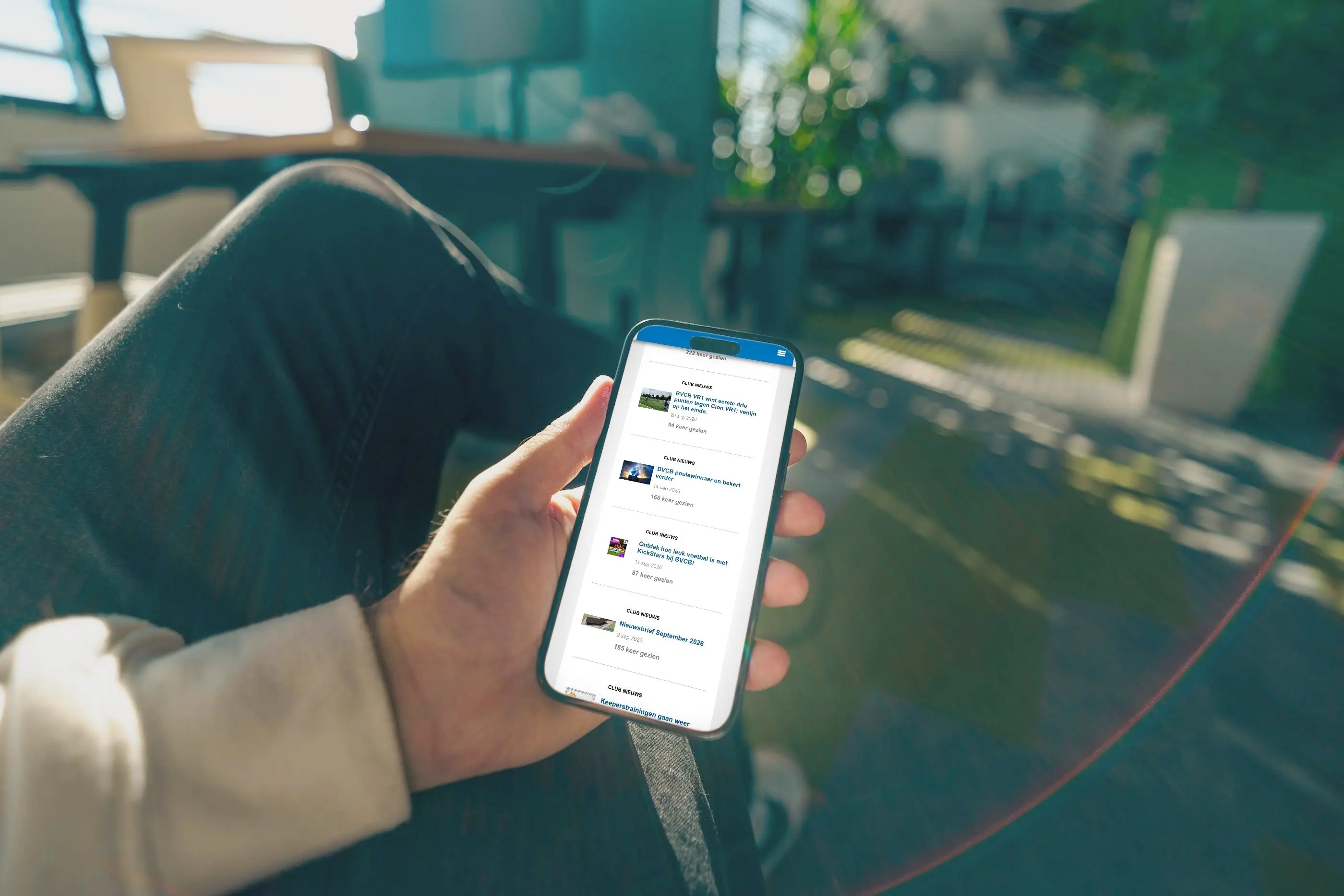 De website van BVCB op het scherm van een telefoon in iemands hand.